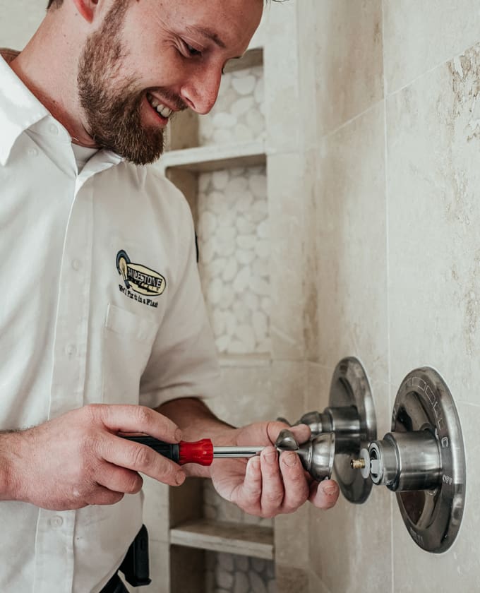 Milestone technician repairing a shower handle